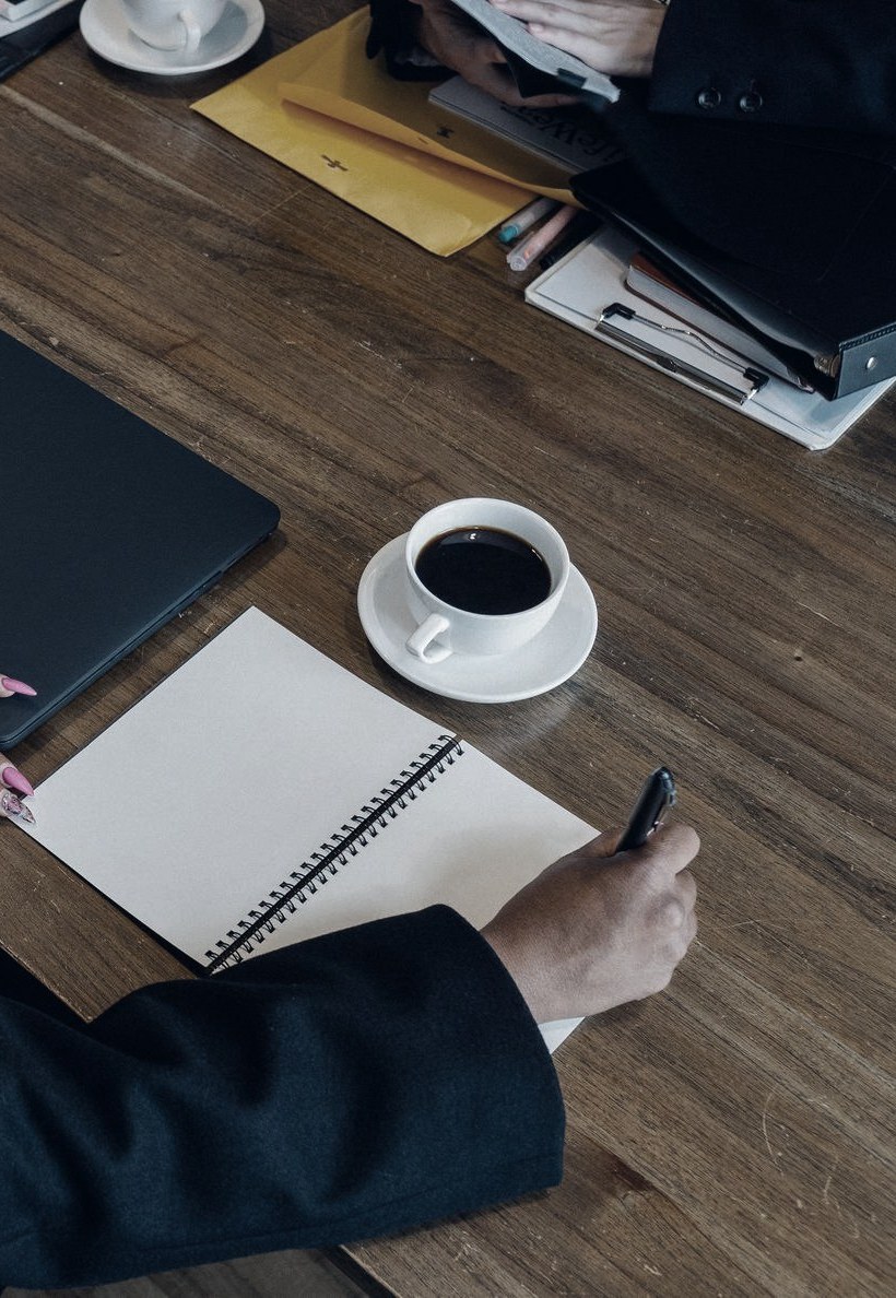 Notebook, laptop and coffee at an advisory meeting
